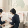 Japanese pharmaceutical safety professionals reviewing package insert revision documents.